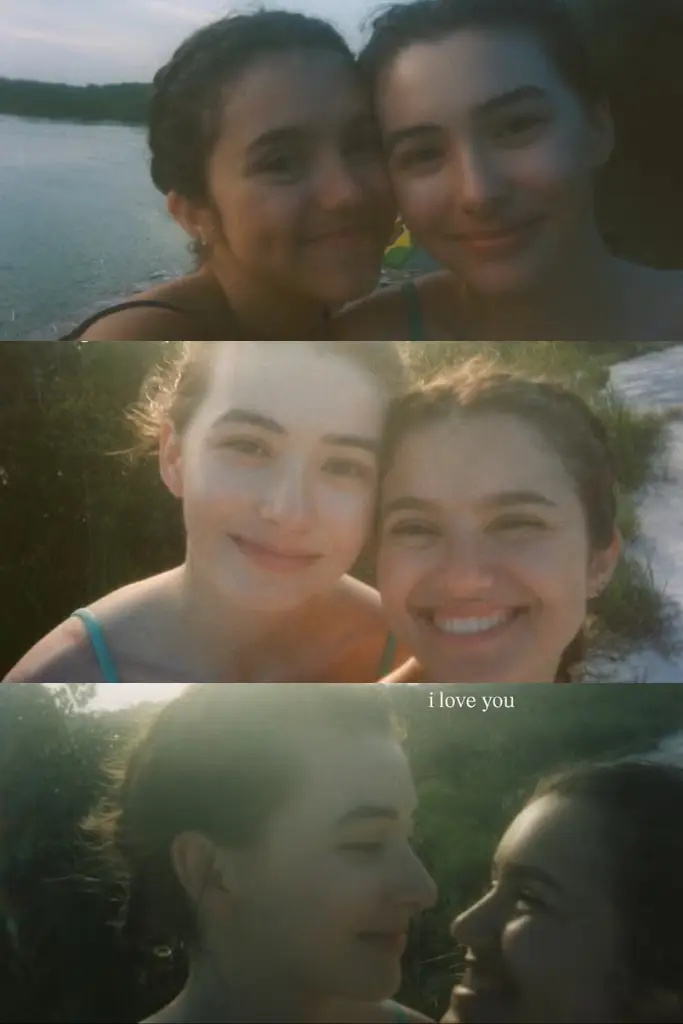 Uma colagem vertical de três fotos granuladas, em estilo vintage, capturadas ao pôr do sol. A primeira imagem mostra Elisa Annenberg-Paglia e Karlie Jo Dickinson sorrindo juntas perto da água. A segunda mostra as duas rindo para a câmera com forte luz de fundo. A terceira mostra as duas em close, olhando uma para a outra amorosamente, com o texto "i love you" em uma fonte serifada sutil no canto superior direito.