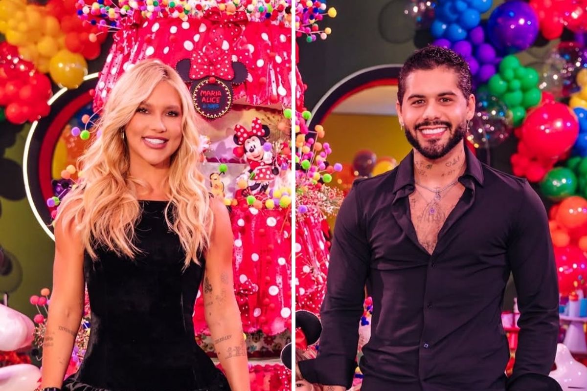 Influenciadora Virginia Fonseca, sorridente com cabelos loiros e longos e vestido preto, ao lado do cantor Zé Felipe, com camisa preta aberta no peito e barba, em uma festa de aniversário decorada com o tema da Minnie Mouse, balões coloridos e doces em tons de vermelho, amarelo e azul.