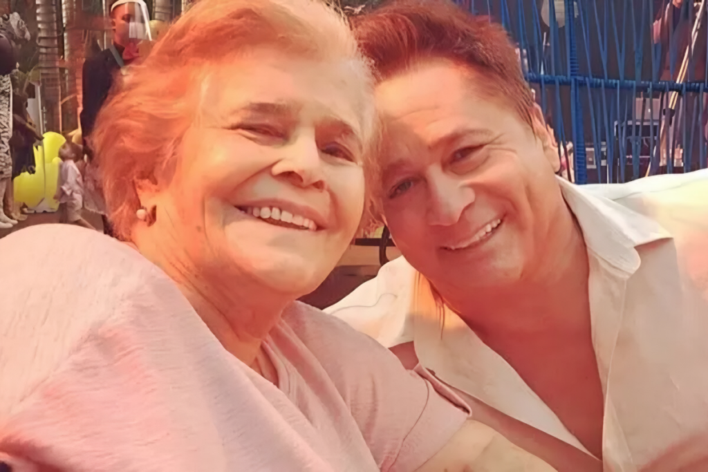 Cantor Leonardo sorrindo abraçado com sua mãe, Dona Carmem, em um momento de carinho e descontração.