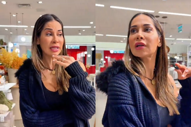 Maira Cardi vestindo casaco de lã escuro com capuz de pelos, conversando em uma loja com decoração ao fundo.