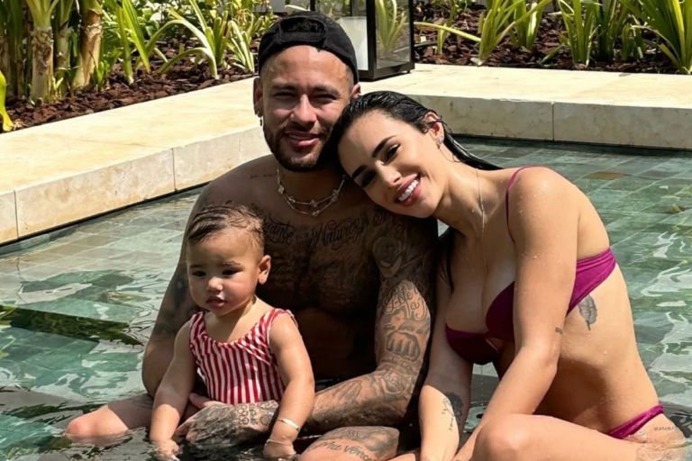 Neymar, Bruna Biancardi e a filha Mavie sentados juntos em uma piscina durante momento de lazer em família.