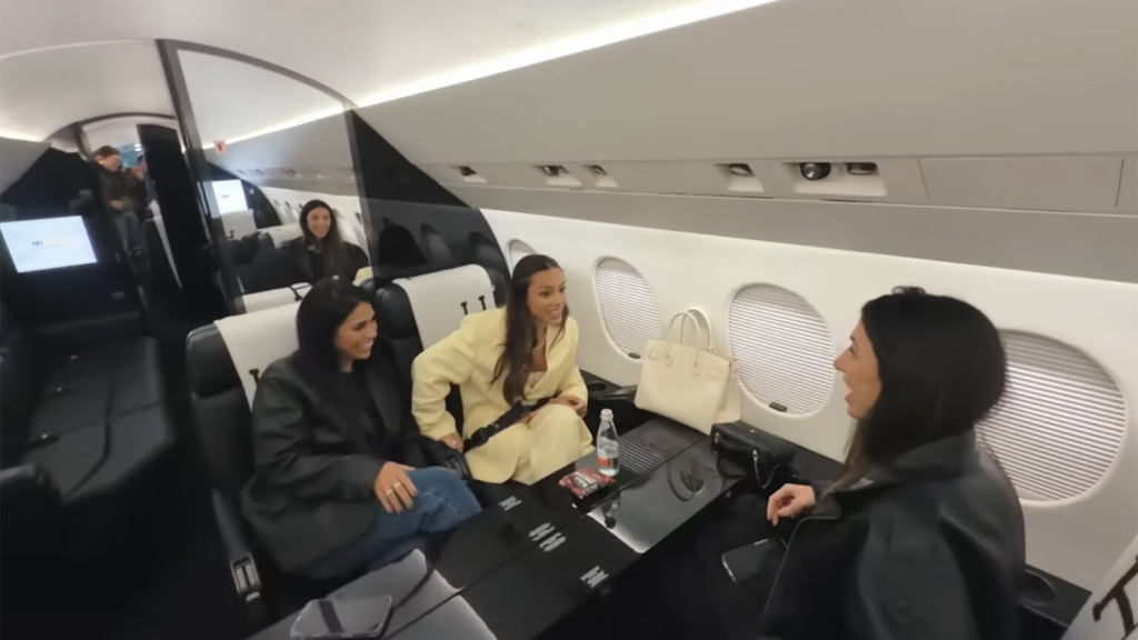 Interior luxuoso do jato particular de Neymar com poltronas de couro preto, mesas individuais, telas de entretenimento e acabamento refinado.
