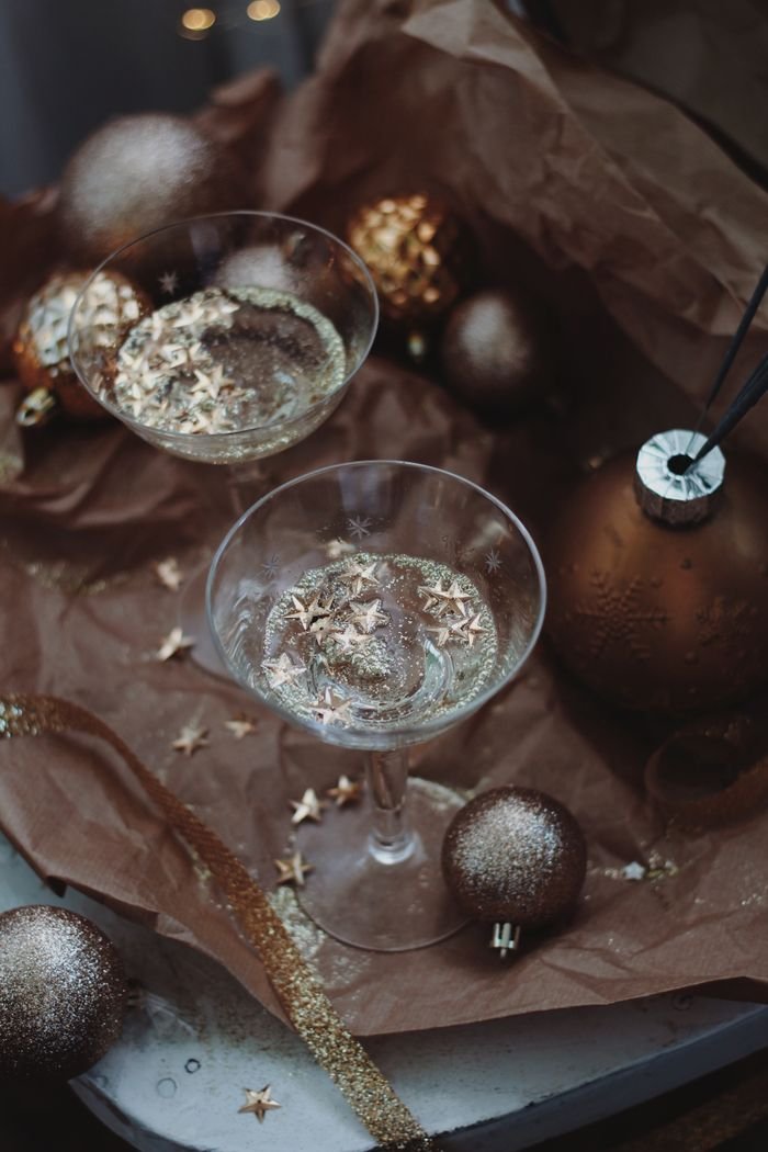 Top view of champagne flutes with star decorations and ornaments, perfect for holiday celebrations.